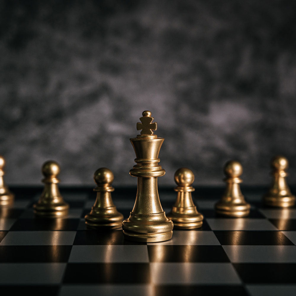 cover image for an article listing some of the best tactical board games, a board of chess with golden figures in the picture